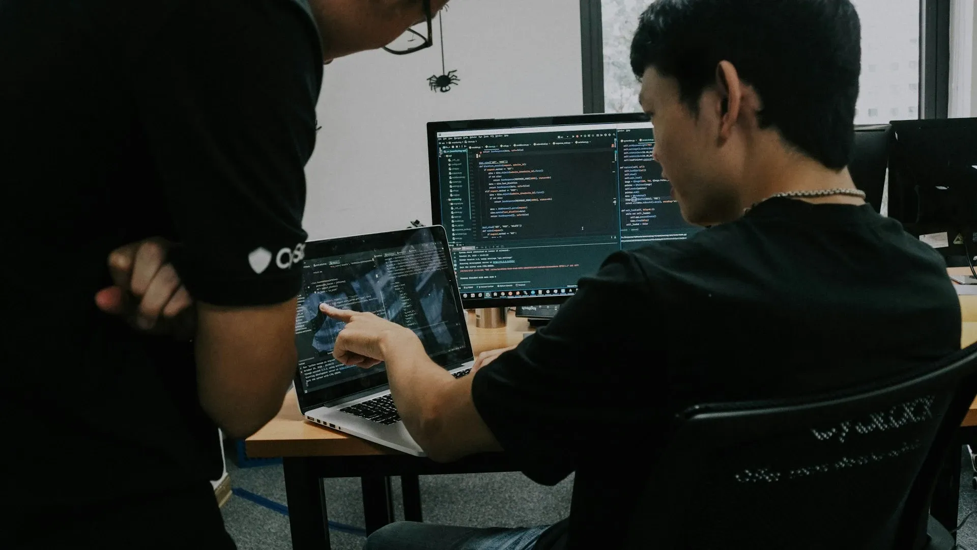 Two devs working together in front of a computer.